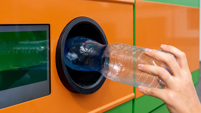 Recycling station collecting bottle through return opening.