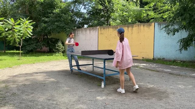 Outdoor sport - two Women Engage In Lively Table Tennis Game