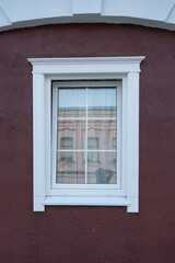 Fototapeta premium static window on painted wood facade with reddish-brown accents in neutral setting, exterior straight-on view, commercial real estate backdrop, white and reddish-brown colors, clean and unv.
