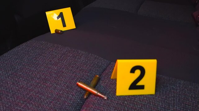 Crime scene investigation with evidence markers next to bullet casings on a car back seat. Flashing blue and red police lights illuminate the interior, and a UV light reveals forensic traces