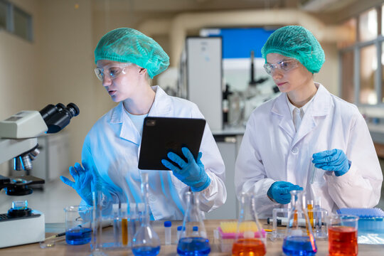 Two female scientists conducting a laboratory experiment while examining samples