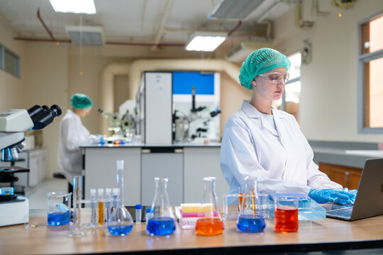 Female scientist using a microscope while conducting scientific research and analyzing samples