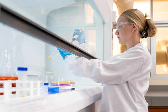 Medical Research Laboratory Portrait of a Beautiful Female Scientist in Goggles Using Micro Pipette for Test Analysis. Advanced Scientific Lab for Medicine, Biotechnology, Microbiology Development