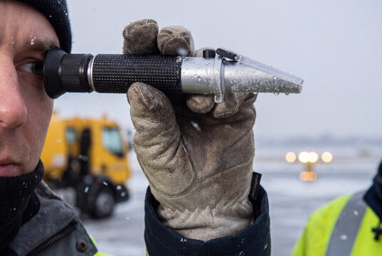 Airport Technician Testing Deicing Fluid With Refractometer in Cold Winter Weather
