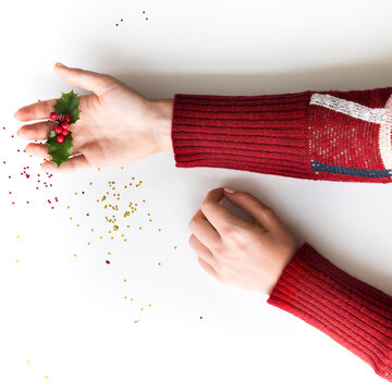 Hands with holly leaves and berries