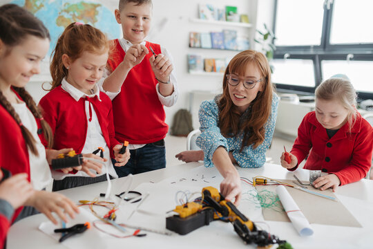 Primary school students learning robotics and technology during STEM class.