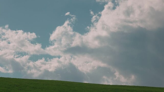 Gentle Sloping Grassland Under a Blue Sky with Clouds