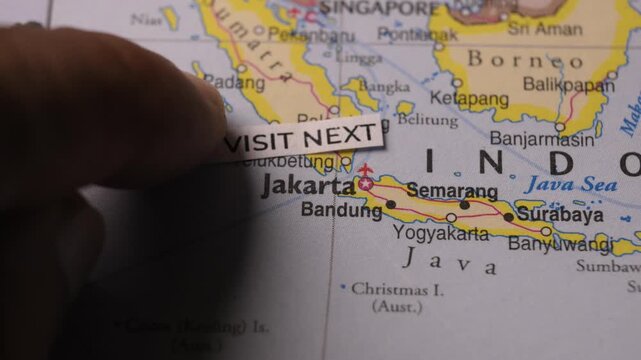Person Placing Visit Next Label on Map Near Jakarta Indonesia