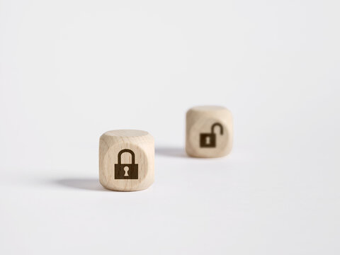 Wooden cubes showing locked and unlocked padlock symbols