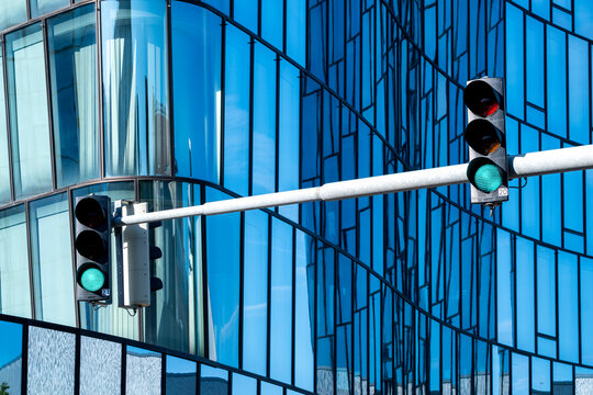 Traffic signal in front of a modern glass office facade in Vienna, Austria, combining urban transport infrastructure with contemporary architecture