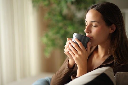 Woman relaxing drinking coffee and enjoying in a house
