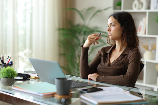 Young pensive telecommuter contemplating working at home