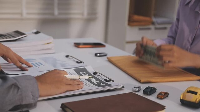 Car sale or rental concept, Closeup Dealership manager signing car insurance document or lease paper contract. Customer with car dealer agent making deal, sign on agreement document contract in office