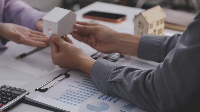 Business professionals meet with real estate agents to discuss real estate investments, sign contracts, apply for mortgages, plan purchases, ownership, and successfully secure approval for