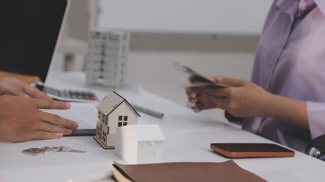 Business professionals meet with real estate agents to discuss real estate investments, sign contracts, apply for mortgages, plan purchases, ownership, and successfully secure approval for