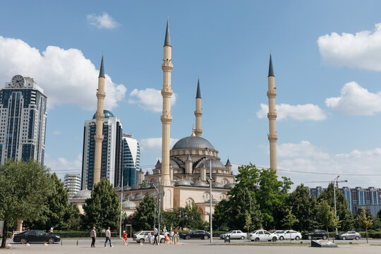 Grozny, Russia - July 2, 2025: Daytime cityscape of the Heart of Chechnya Mosque with tall minarets and central dome, framed by modern high rises and street traffic in Grozny, Chechnya, Russia