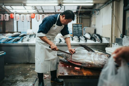 Fishmonger breaking down a large tuna on the slab