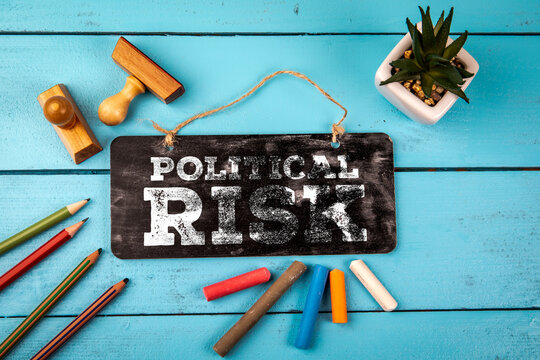 POLITICAL RISK Message on Chalkboard With Colorful Office Supplies