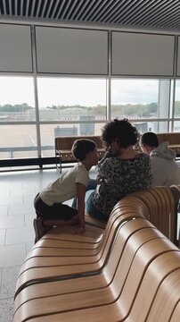 Mother and two sons waiting at airport terminal
