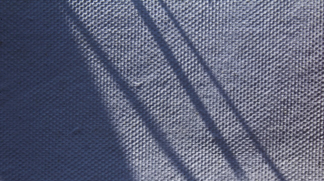 Abstract parallel stripe shadows on white textured fabric for overlay or background.