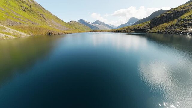 Low FPV flight over calm alpine lake reflecting clouds