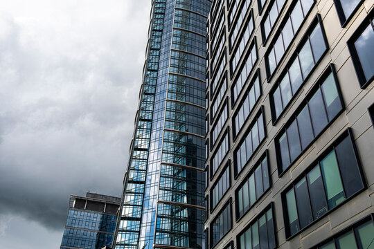 Low angle view of modern office towers in the financial district of Warsaw, Poland beneath a dramatic cloudy sky in the city center