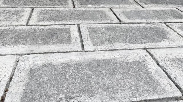 Angled perspective of grey rectangular paving blocks pavement texture