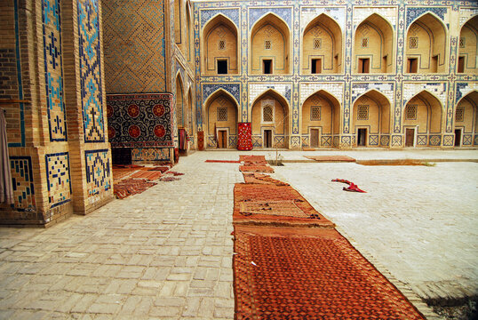 Arched entrance with carpets in the courtyard, Bukhara, Uzbekistan