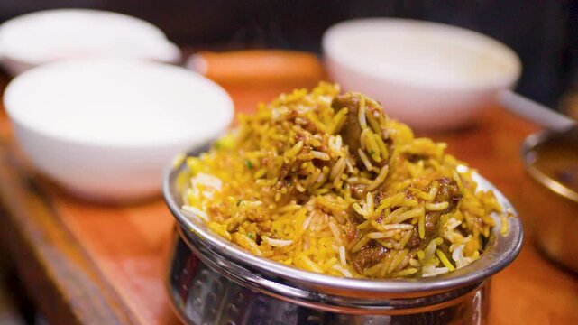 Chef Garnishing Hot Indian Biryani with Fresh Cilantro Leaves