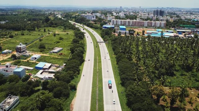 4K aerial view of traffic on the Bengaluru&ndash;Mysuru Expressway in Karnataka, India, showcasing modern highway infrastructure, divided carriageways, and surrounding urban development.