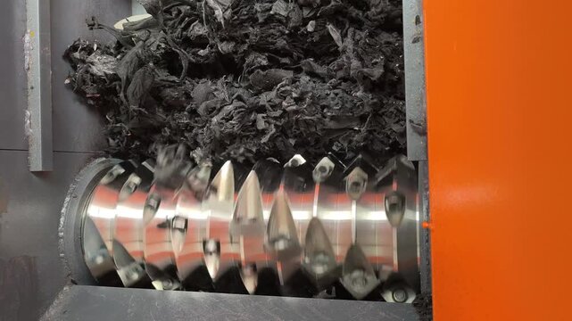 Close-up of shredder blades rotating to grind material.
