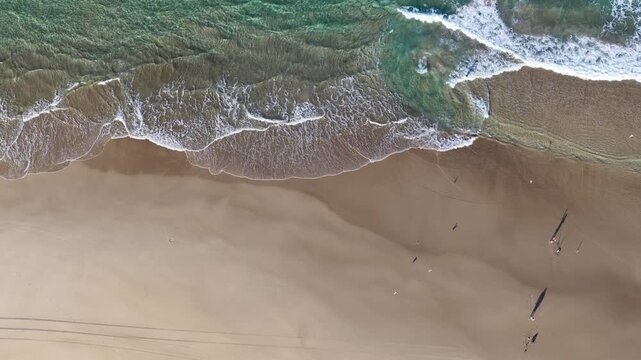 Aerial Top Down View of Ocean Waves Crashing on Sandy Beach