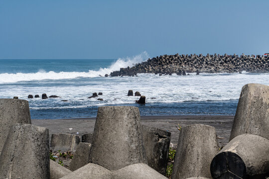 Large concrete breakwater structure resisting strong ocean waves on the coast
