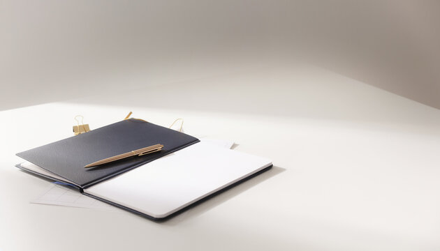 Open notebook and tablet resting on a minimalist white desk with copy space.