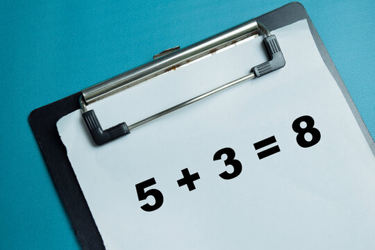 Concept of simple 5+3=8 math equation write on clipboard isolated on table. For basic arithmetic and school education