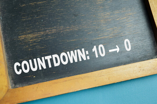 Chalkboard with phrase countdown from ten to zero on wooden desk. For symbolizing time and deadline