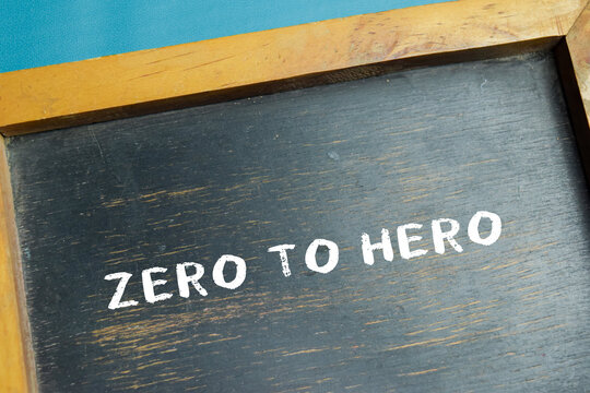 Chalkboard with phrase zero to hero on wooden desk. For symbolizing personal growth and transformation
