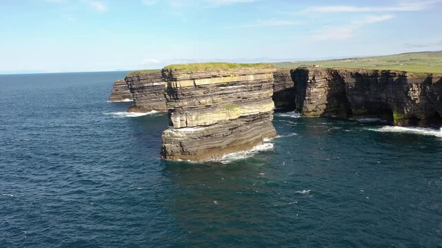 Aerial view of the iconic Dun Briste sea stack with its distinct layered rock formations rising from the Atlantic Ocean near the cliffs of Ballycastle, County Mayo, Ireland.