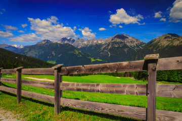 Alpine mountain panorama behind a rustic wooden fence © Tom Pavlasek