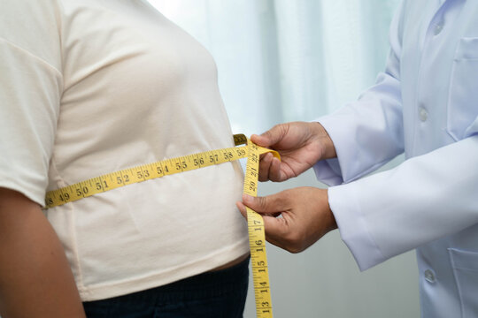 Asian woman with fat belly big size overweight and obesity with measure tape.