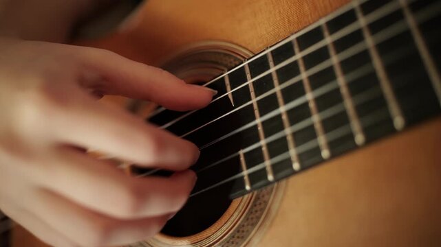 Fingers plucking classical guitar strings close-up, cinematic performance detail, nylon strings, warm wooden tones. live musical performance, making it ideal for music, arts, culture