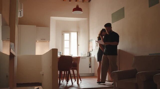 Stressed couple arguing over finances, bills, and mortgage documents in their modern apartment, highlighting relationship problems, debt, and economic anxiety