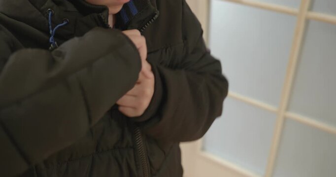 Close-up children's hands zipping zip jacket. 4K 10-bit