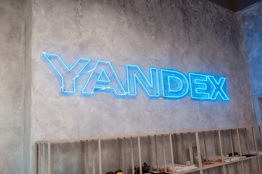 August 2, 2026, Belgrade, Serbia: Yandex neon logo sign glowing blue on concrete wall at company office or retail space.