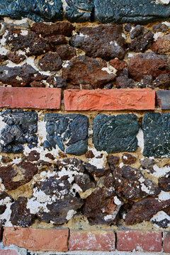 Historic wall texture made of dark slag blocks and red bricks