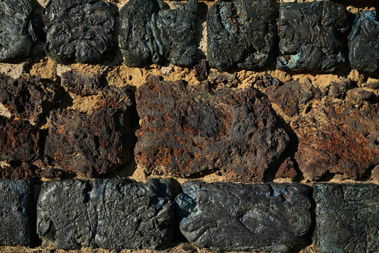 Historic wall texture made of dark slag blocks and red bricks