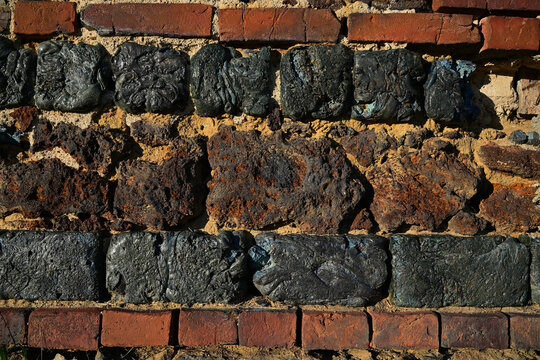 Historic wall texture made of dark slag blocks and red bricks