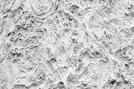 White relief plaster texture with dynamic fiber swirls. Expressive high-key background with rich tactile depth. Ideal background for artistic design and architecture projects.