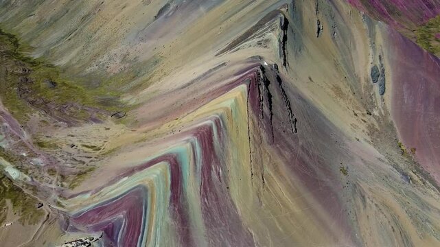 Aerial view of the colorful mineral layers of Vinicunca mountain with rugged terrain and steep slopes in Quispicanchi Province, Cusco, Peru.