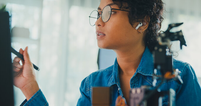 Close-up African American female robotics engineer discussing mechanical part on video call in laboratory. Remote work, virtual training, online meeting, future technology, technical support concept.